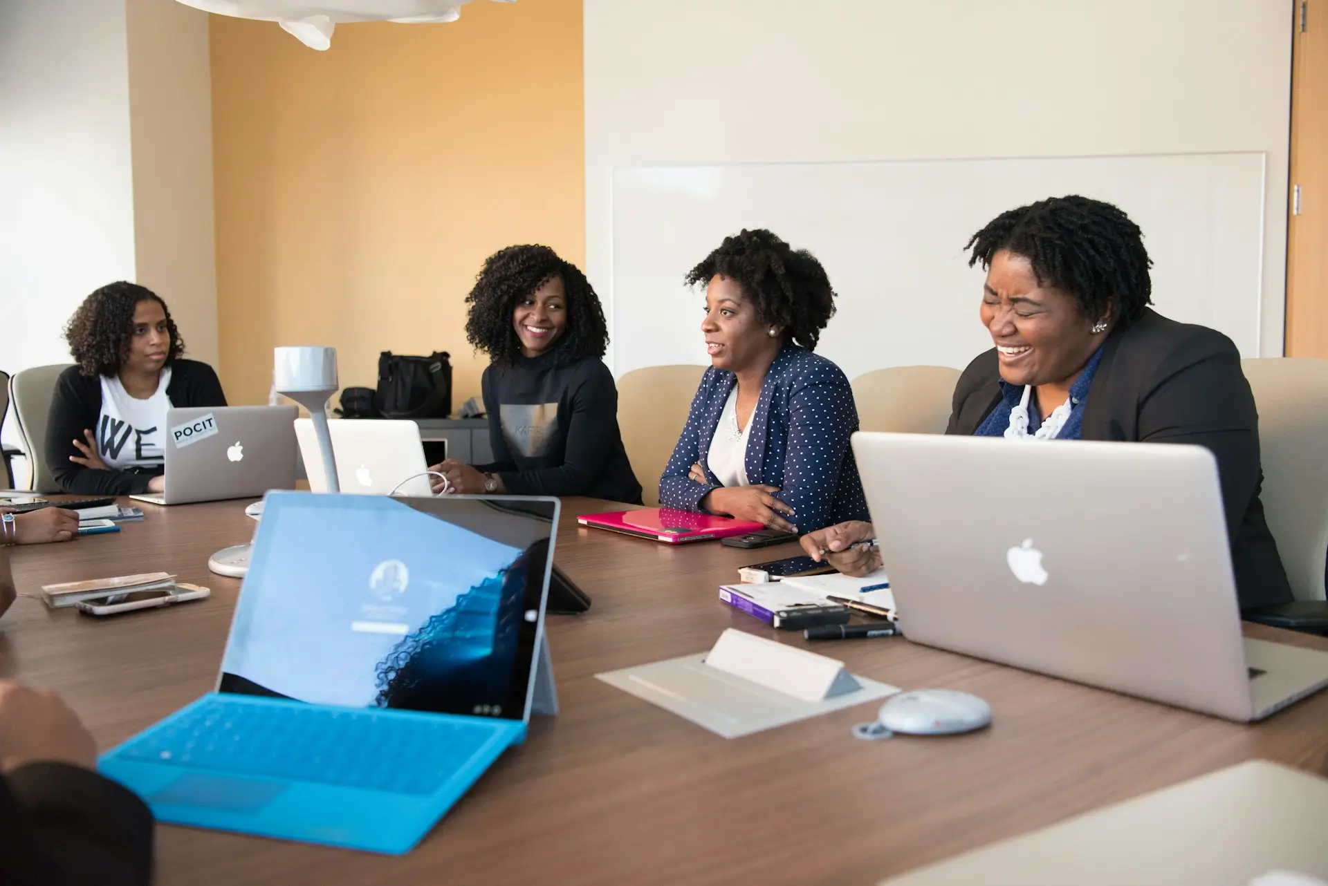 A group of black women sitting in an office having a meeting.